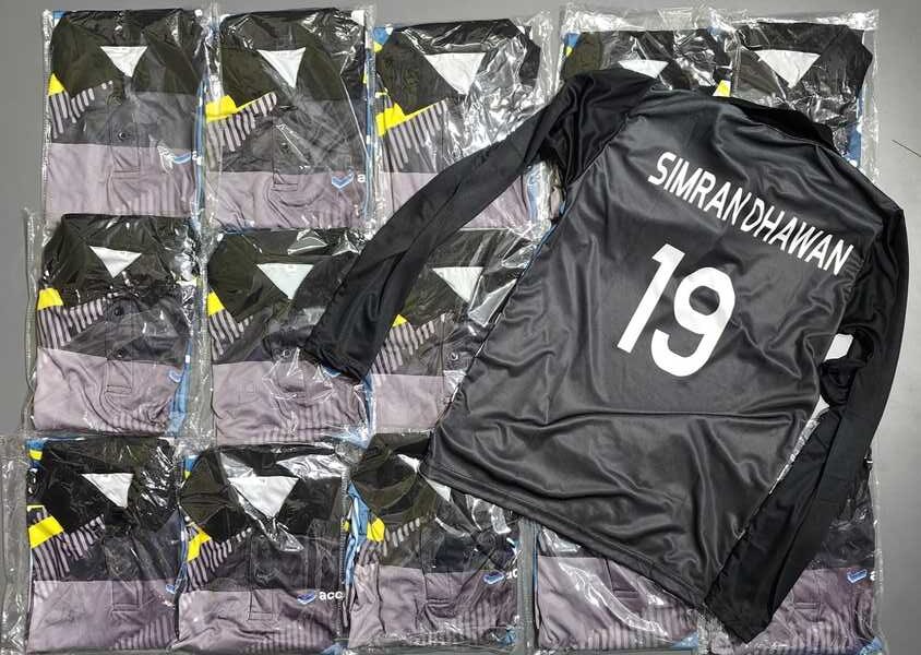 stack of custom sports jerseys with one personalized on top showing player name and number